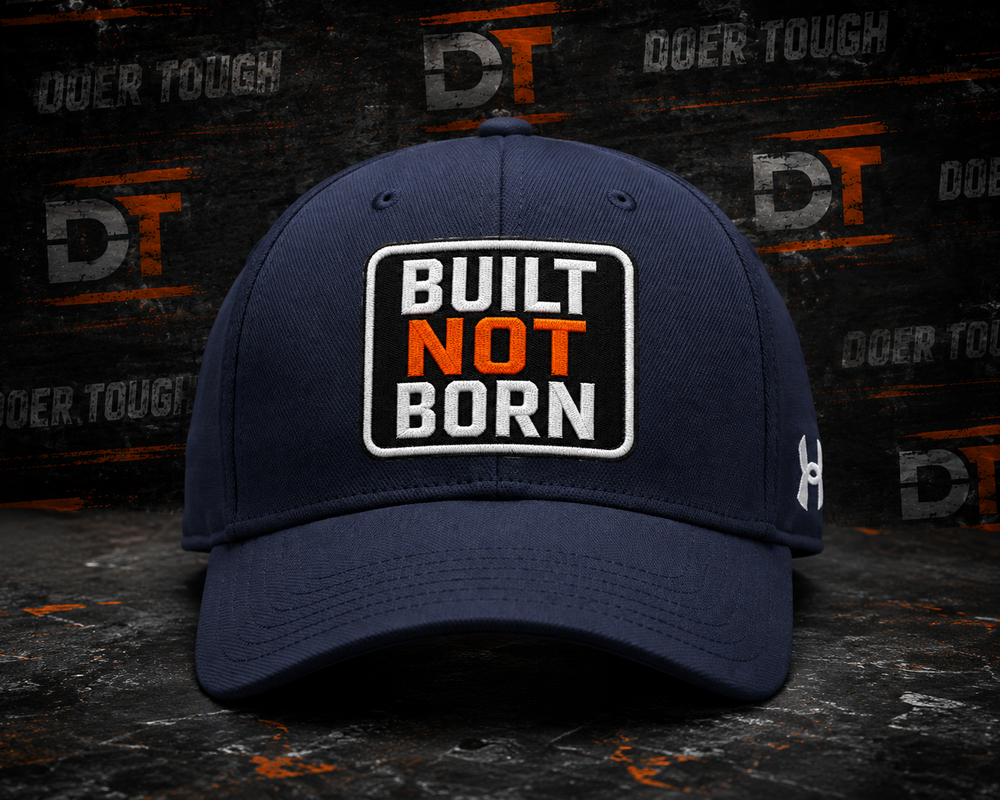 Doer Tough performance cap with BUILT NOT BORN patch on an Under Armour blank
